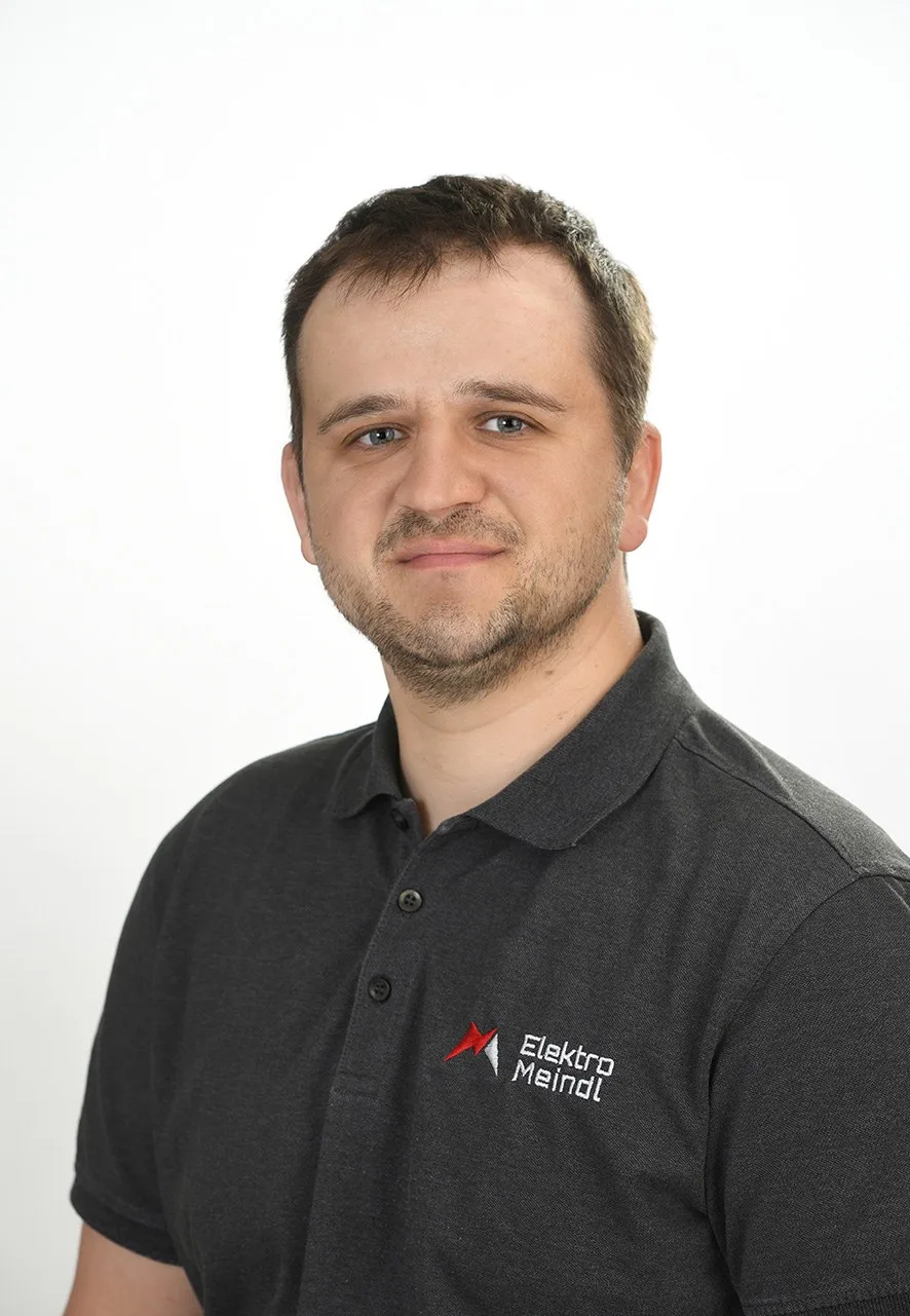 Porträt von Christoph Groll im dunklen Polo mit Logo von Elektro Meindl