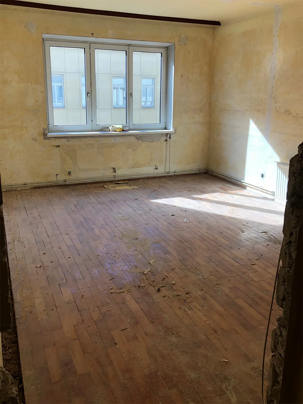 Raum in der Fasangasse vorher: alter Holzboden, fleckige Wände